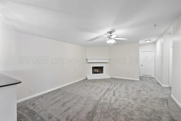 an empty room with windows and ceiling fan