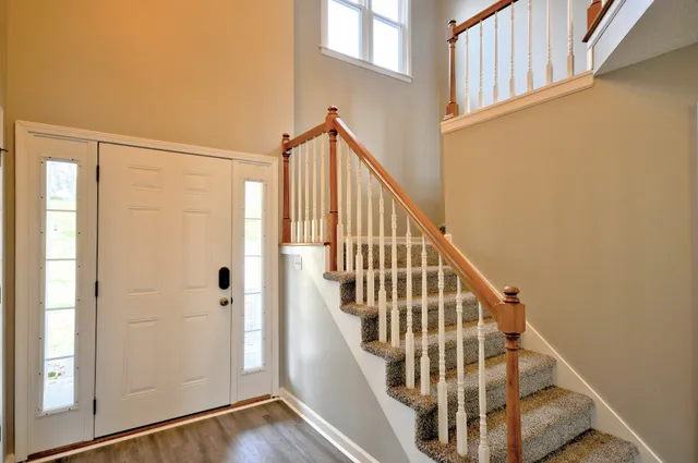 a view of staircase with wooden floor and white walls