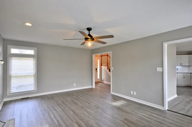 a view of wooden floor and a ceiling fan in a room