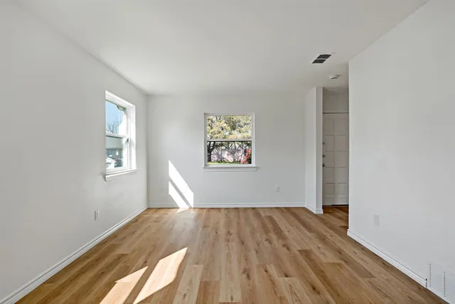a view of empty room with wooden floor