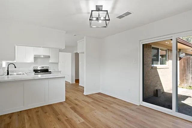 a kitchen with stainless steel appliances a sink cabinets and wooden floor
