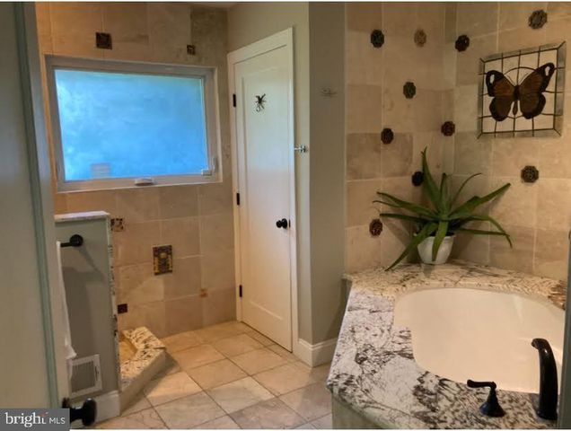 a spacious bedroom with a bed and a chandelier