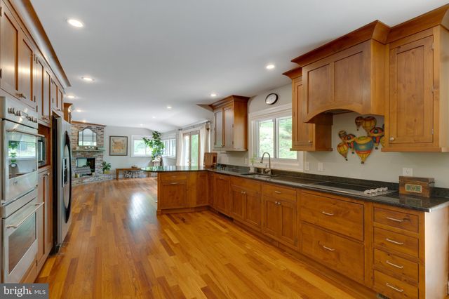 a kitchen with kitchen island granite countertop a stove refrigerator and microwave