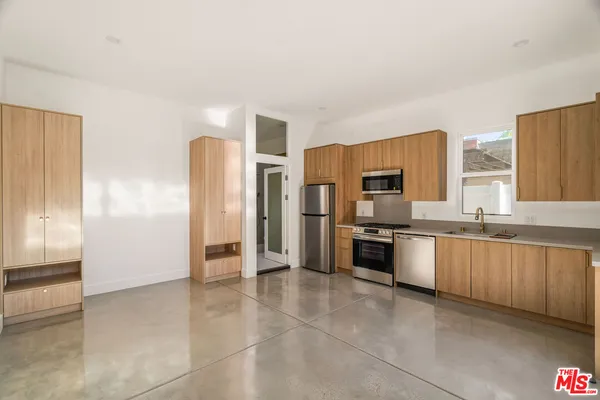 a large kitchen with cabinets and stainless steel appliances