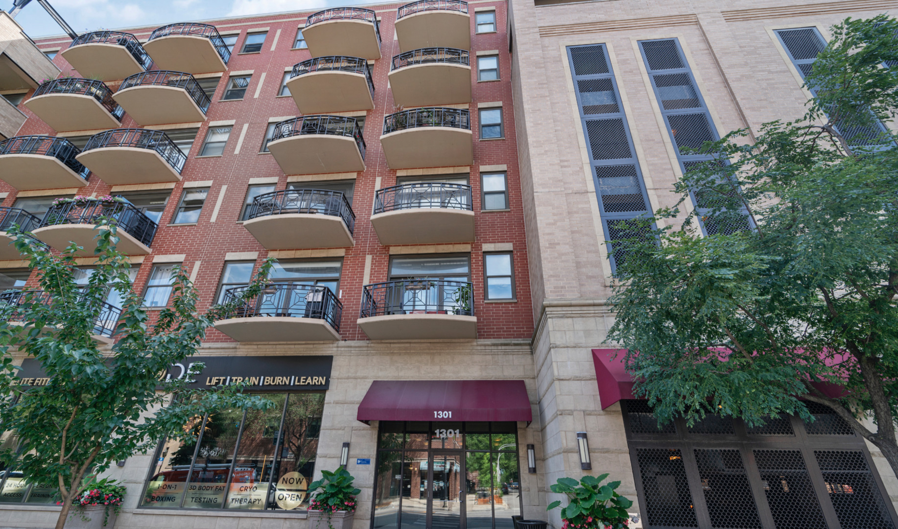 1301 West Madison Street, Unit 203 Chicago, IL 60607 - Photo 1 of 14 a view of a building with a lot of flower plants