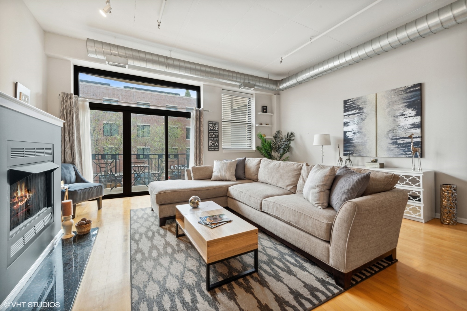 1301 West Madison Street, Unit 203 Chicago, IL 60607 - Photo 3 of 14 a living room with furniture and a fireplace