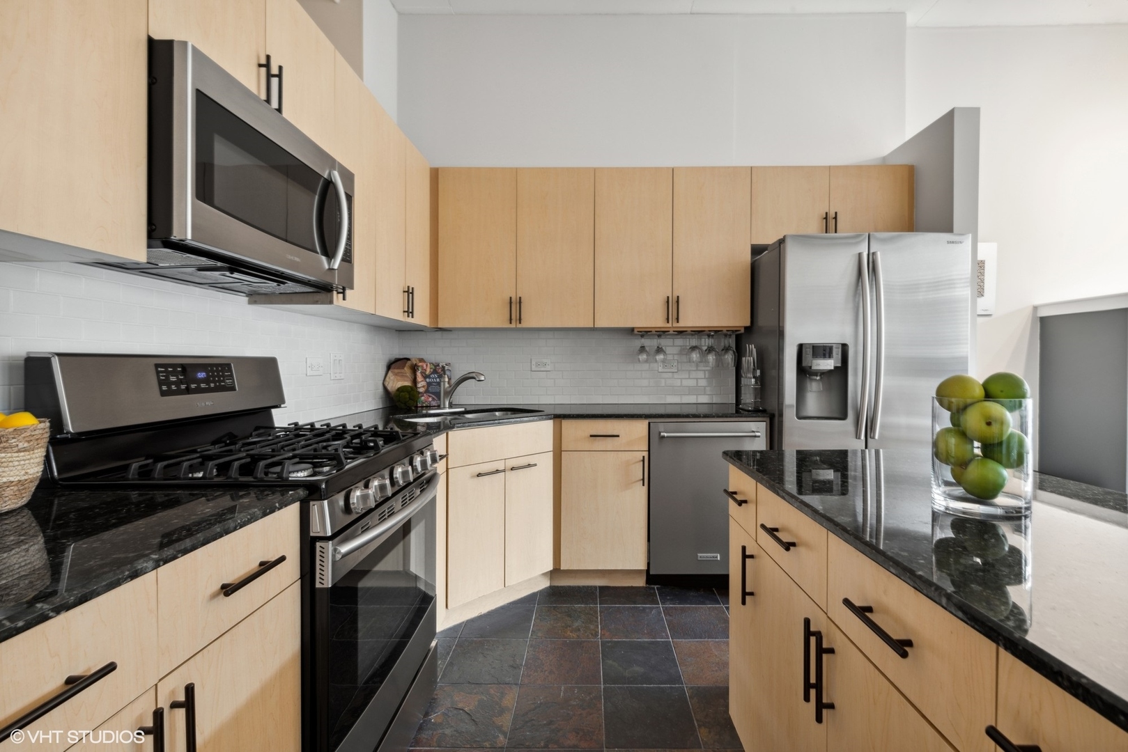 1301 West Madison Street, Unit 203 Chicago, IL 60607 - Photo 5 of 14 a kitchen with stainless steel appliances granite countertop a refrigerator a stove top oven a sink and dishwasher