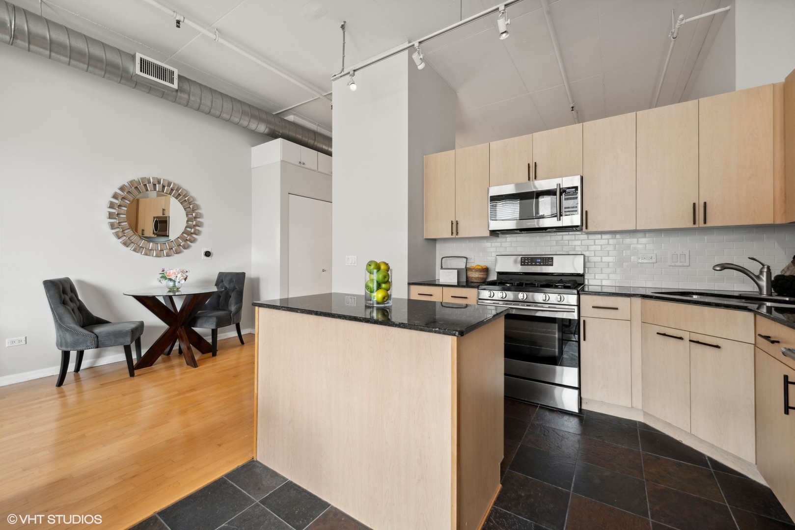 1301 West Madison Street, Unit 203 Chicago, IL 60607 - Photo 6 of 14 a kitchen with stainless steel appliances kitchen island granite countertop a sink and cabinets