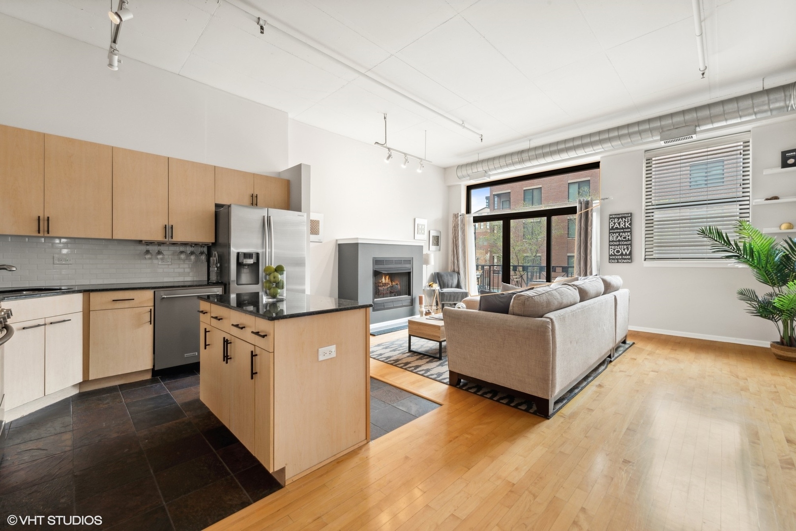 1301 West Madison Street, Unit 203 Chicago, IL 60607 - Photo 8 of 14 a kitchen with stainless steel appliances granite countertop a stove top oven a sink dishwasher a dining table and chairs with wooden floor