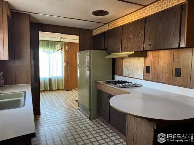 a kitchen with stainless steel appliances granite countertop a refrigerator a stove and a sink
