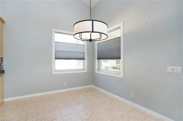 an empty room with a window and a chandelier