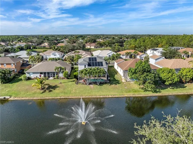 an aerial view of residential houses with outdoor space and lake view
