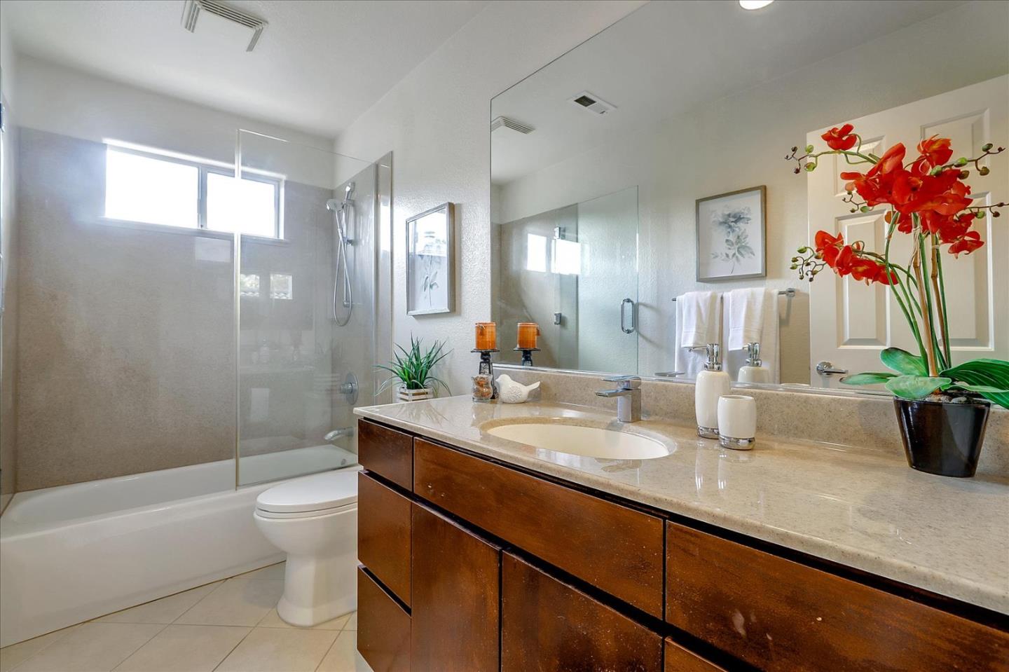5803 Killarney Circle San Jose, CA 95138 - Photo 37 of 57 a bathroom with a granite countertop sink a toilet a mirror and shower