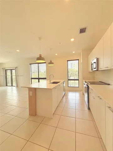 a large kitchen with stainless steel appliances a refrigerator and a stove top oven