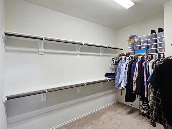 a view of walk in closet with clothes and shoes