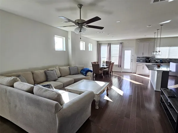 a living room with furniture wooden floor and a window