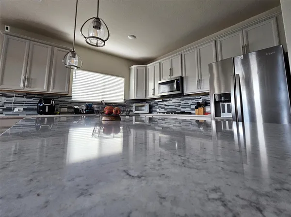 a kitchen with stainless steel appliances granite countertop a stove a refrigerator a sink a stove with wooden cabinets and floor