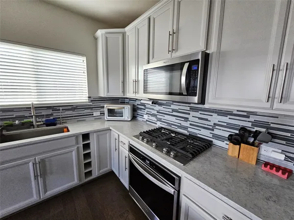 a kitchen with stainless steel appliances granite countertop a sink stove and cabinets