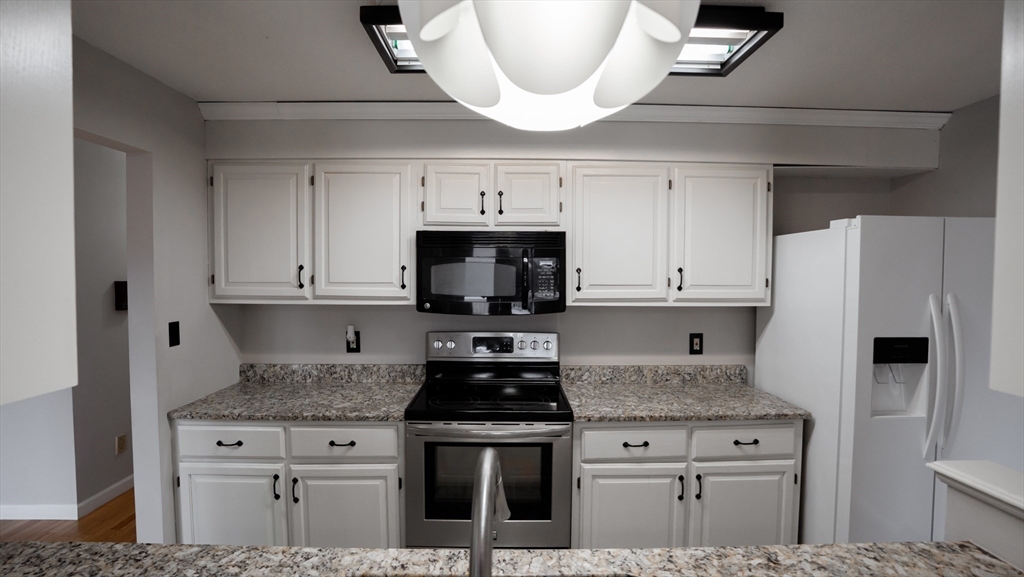 2205 Boston Road, Unit M120 Wilbraham, MA 01095 - Photo 4 of 19 a kitchen with stainless steel appliances granite countertop a stove a refrigerator and a microwave