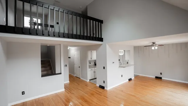 a view of a hallway with wooden floor and staircase