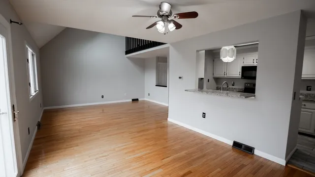 a view of a kitchen with wooden floor and a ceiling fan