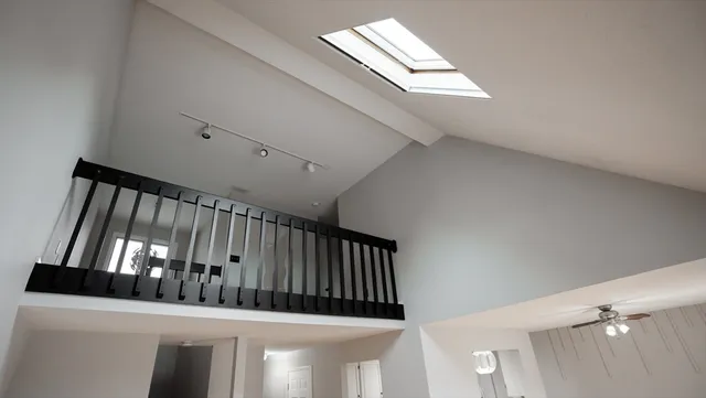 a view of staircase with lots of frames on wall and a window