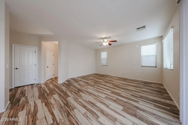 a view of empty room with window and ceiling fan