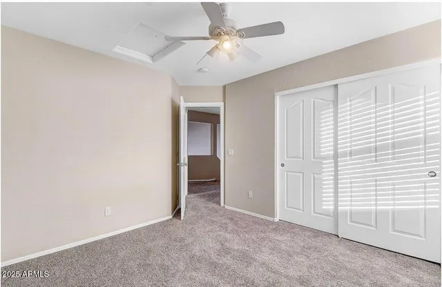 an empty room with a ceiling fan and a window