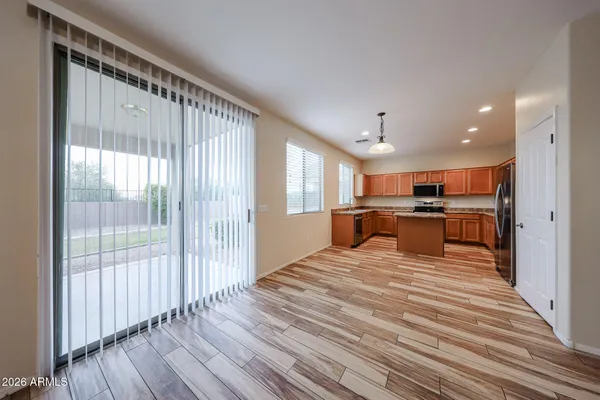 a large white bedroom with wooden floor white walls and windows