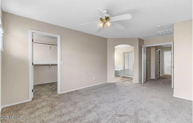 a view of an empty room with closet and a chandelier fan