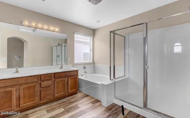 a spacious bathroom with a tub sink and mirror