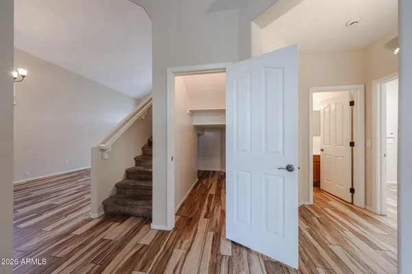 a view of a hallway with wooden floor and staircase