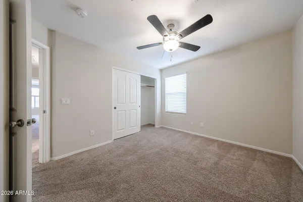 an empty room with a ceiling fan and a window