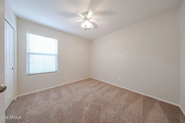 an empty room with windows and fan
