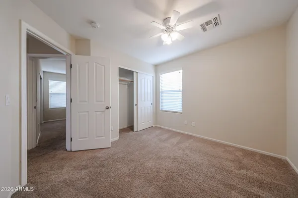 an empty room with chandelier fan