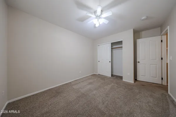 a view of an empty room and a ceiling fan