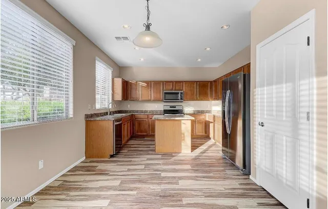 a kitchen with a refrigerator and a stove top oven