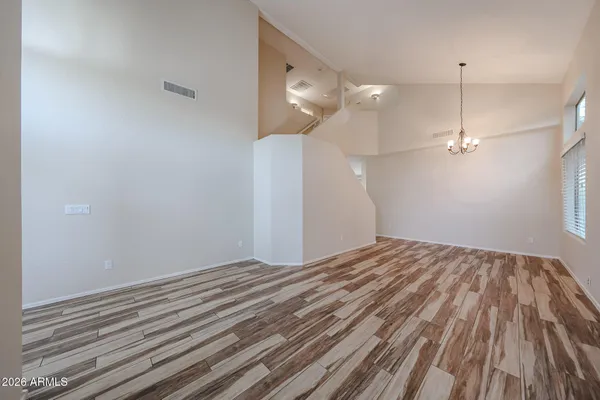 a view of empty room with wooden floor and ceiling fan