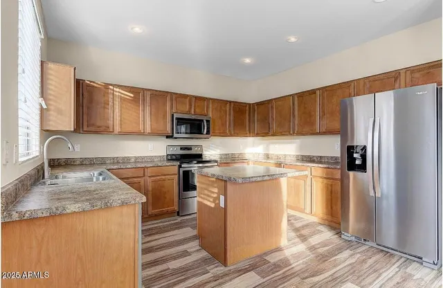 a kitchen with stainless steel appliances granite countertop a refrigerator stove microwave and sink