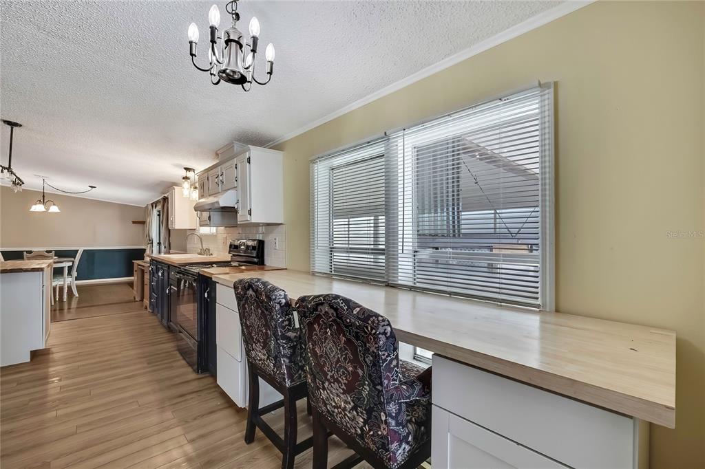 2400 Lemur Drive Holiday, FL 34690 - Photo 16 of 39 a open kitchen with stainless steel appliances granite countertop a stove top oven a sink dishwasher a dining table and chairs with wooden floor