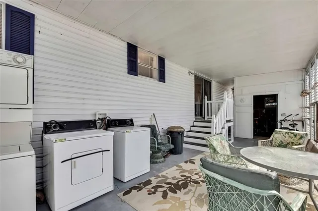 a kitchen with granite countertop a stove a sink a dining table and chairs