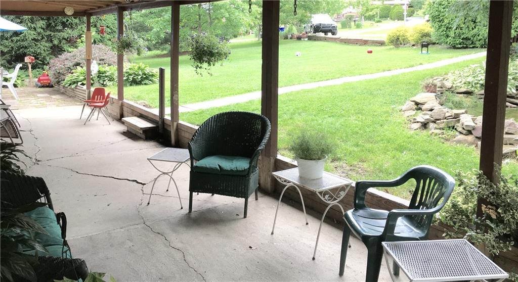 105 Plank Road Acme, PA 15610 - Photo 6 of 25 Large covered porch with a view into the yard towards the driveway.