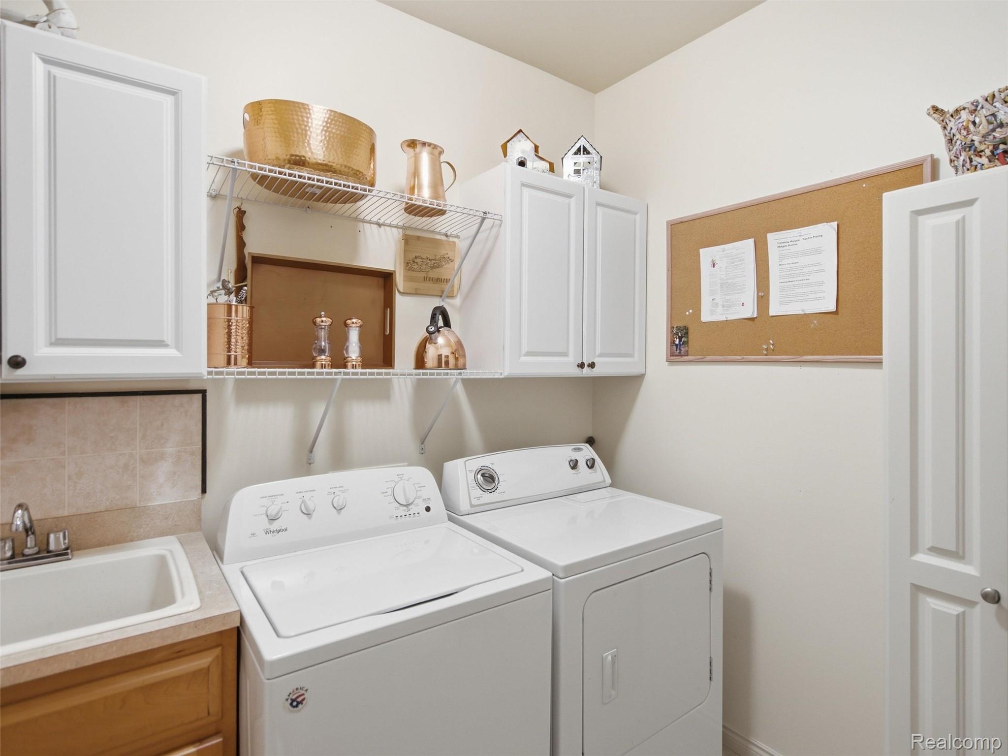 2633 Ridgecrest Drive Utica, MI 48316 - Photo 15 of 28 Dedicated laundry space featuring a utility sink custom wood cabinetry, and white overhead storage cabinets