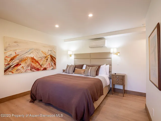 a bedroom with a bed and a painting on the wall