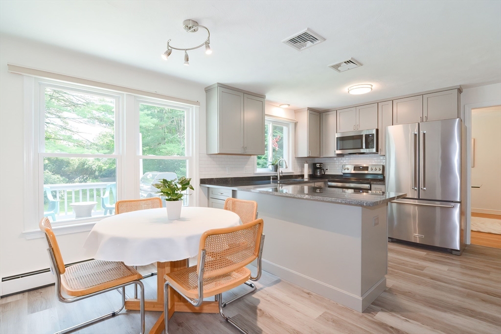 41 Eaton Road Framingham, MA 01701 - Photo 13 of 42 a kitchen with stainless steel appliances a refrigerator a stove a dining table and chairs