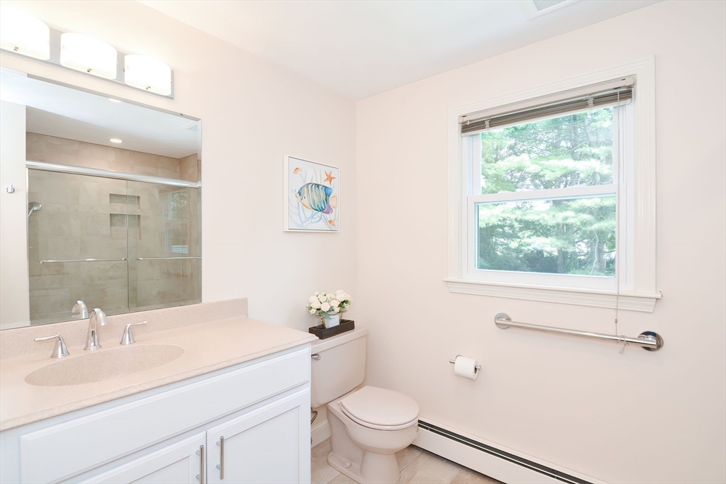 41 Eaton Road Framingham, MA 01701 - Photo 28 of 42 a bathroom with a granite countertop sink a toilet a large mirror and a window
