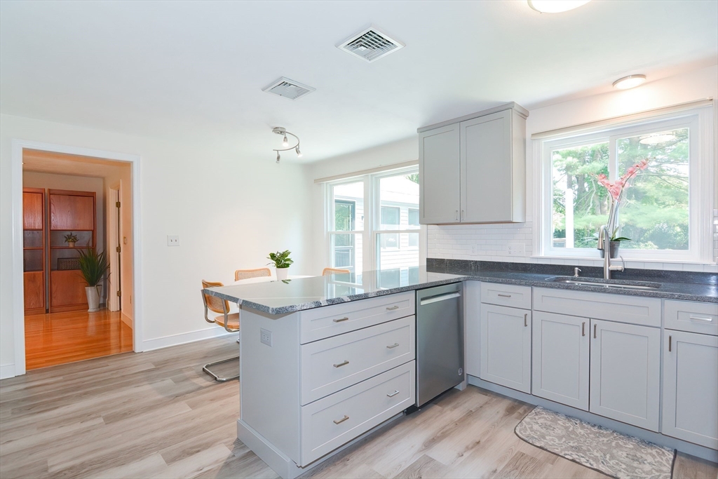 41 Eaton Road Framingham, MA 01701 - Photo 10 of 42 a kitchen with granite countertop cabinets a sink and dishwasher with wooden floor