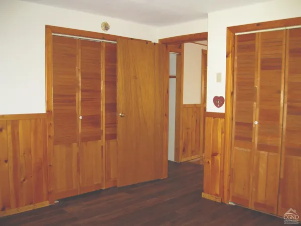 an empty room with wooden floor and door
