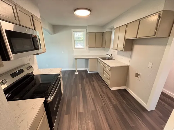 a kitchen with sink a microwave a stove and refrigerator
