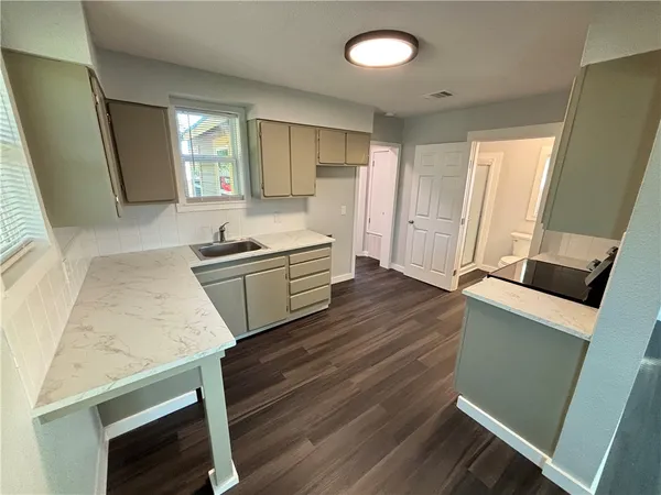 a kitchen with wooden floor and window